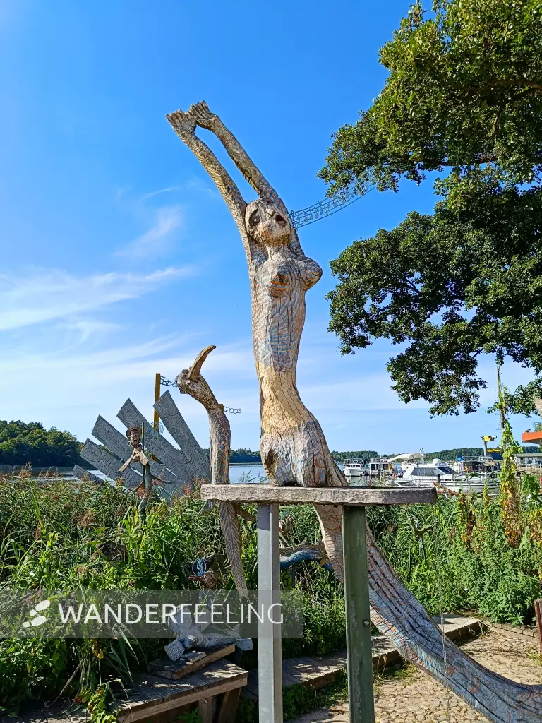 202508110-26 - Holzskulptur an der Uferpromenade in Rheinsberg, Ruppiner Seenland, Brandenburg, Deutschland