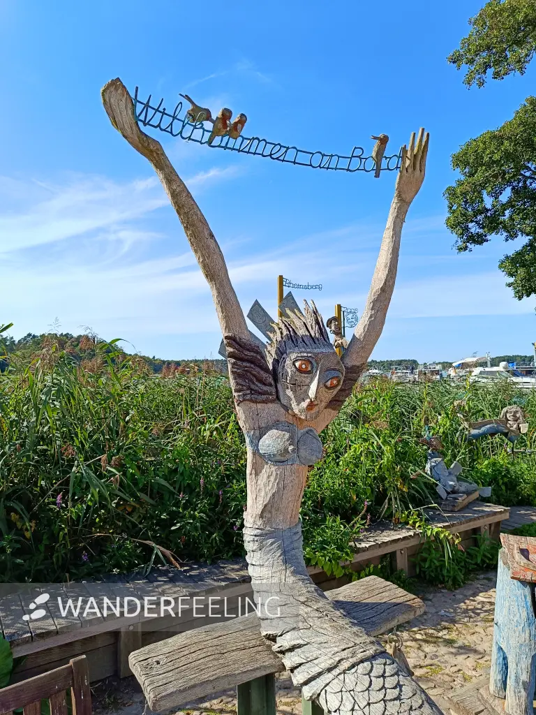 202508110-27 - Holzskulptur an der Uferpromenade in Rheinsberg, Ruppiner Seenland, Brandenburg, Deutschland