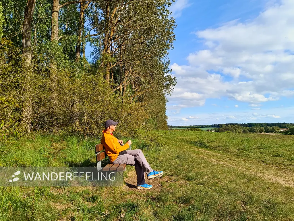 202605040-32 - Wanderer auf einer Bank bei Sternberg, Mecklenburgische Seenplatte, Mecklenburg-Vorpommern, Deutschland