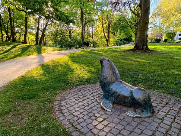 202604231-32 - Seelöwenskulptur im Rosengarten in Neuss, Niederrhein, Nordrhein-Westfalen, Deutschland